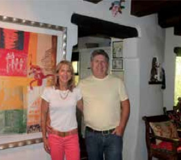 Larry and Kelly Borgeson in their North Valley home, standing next to a favorite lithograph, Clan Destiny, 1996, by Robert Rauschenberg